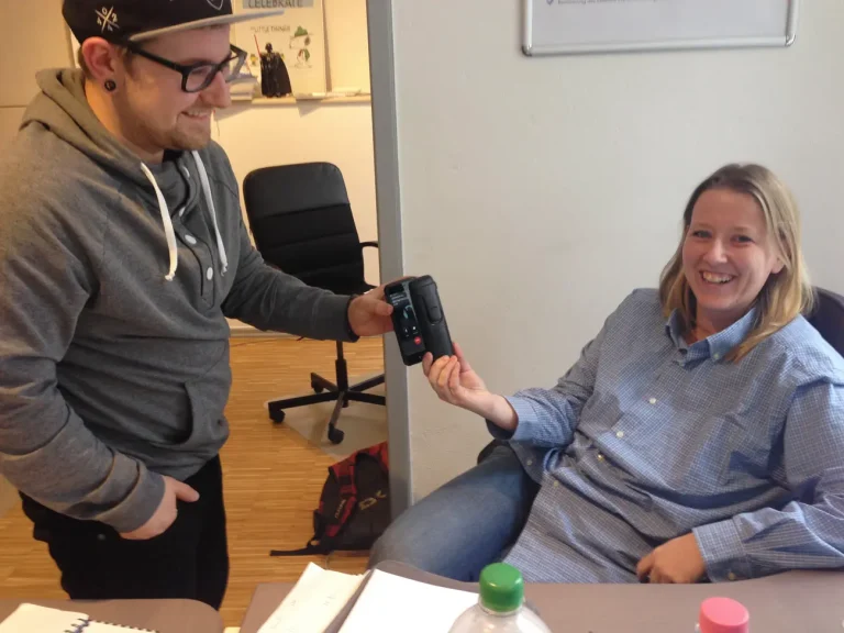 Fabian und Andrea testen das Telefon. Sie halten die beiden Telefone aneinander, damit sie sich verbinden können.