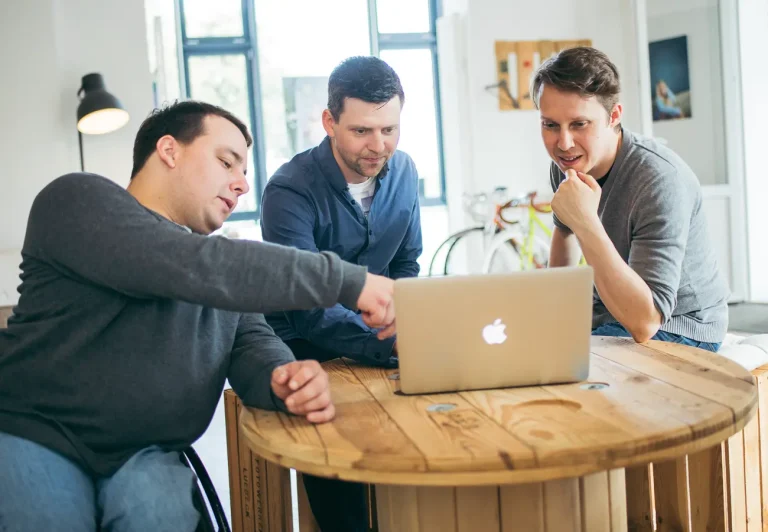 Paul, Michi und Nils in der Diskussion. Sie schauen gemeinsam auf einen Laptop.