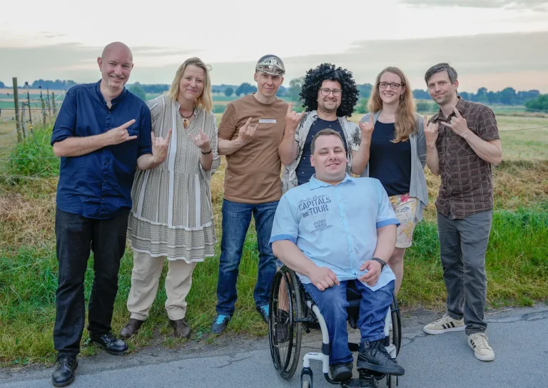Hansolu-Gruppenbild auf dem Sommerfest. Alle zeigen mit den Fingern die Pommesgabel aus dem Heavy Metal.