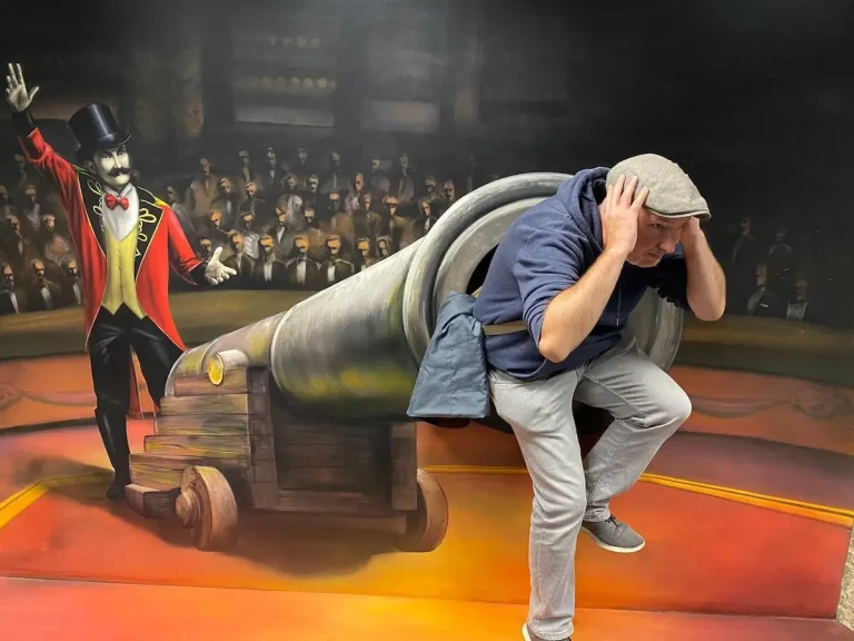 Alex in der Kanone. Im einem Museum für Perspektivverzerrungen hat sich Alex so positioniert, als wenn er sich in einer Kanone befindet.