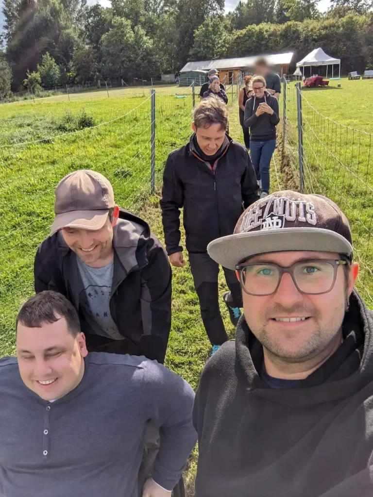Hansolu Teambuilding auf der Alpakafarm. Das Team ist auf einem Weg zwischen den Gehegen unterwegs.