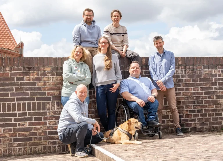 Das Hansolu-Team beim Fotoshooting im Freien. Sie stehen auf der Dachterasse auf dem Hansemuseum.