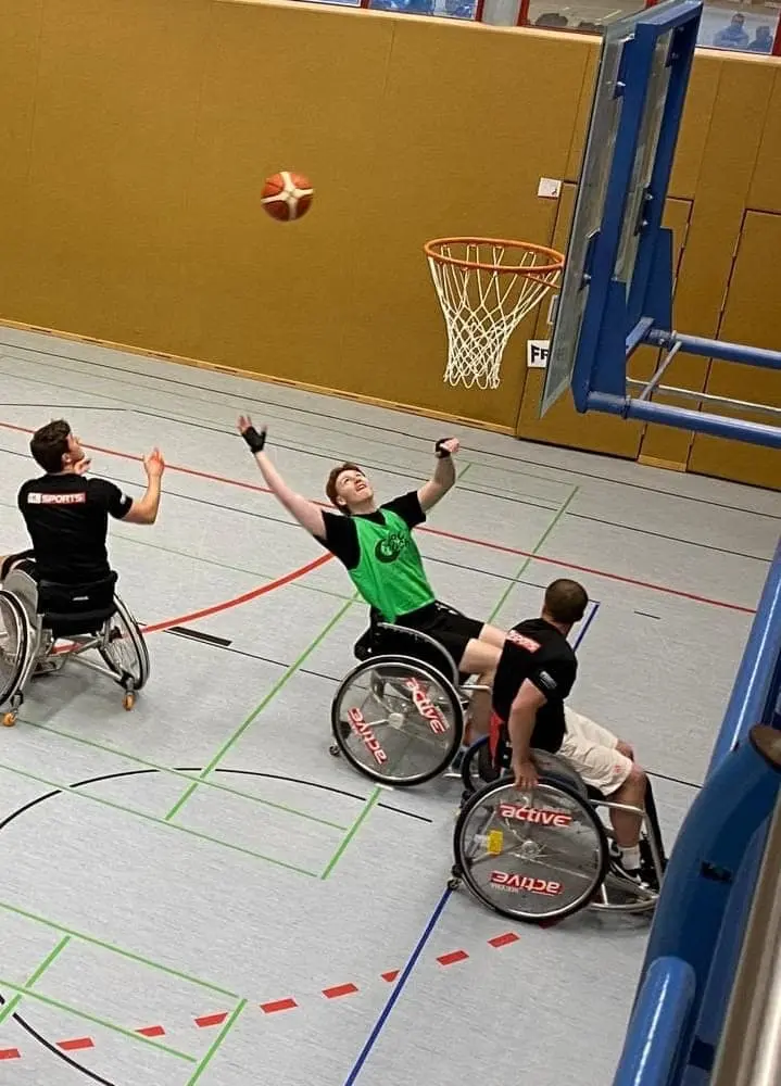Hansolu beim Rollstuhl-Basketballturnier. Erik ist vor dem Korb.
